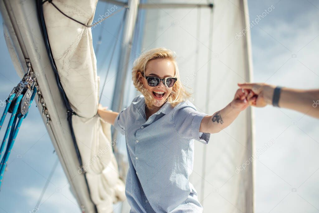 Young caucasian woman enjoying journey on yacht deck sailing the sea.