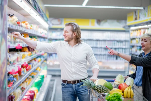 Mensen en schappen met producten in de supermarkt afdeling van het winkelcentrum — Stockfoto