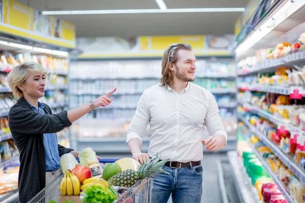 Mensen en schappen met producten in de supermarkt afdeling van het winkelcentrum — Stockfoto