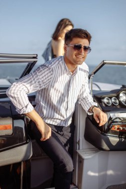 Genç evli çift motorlu teknede deniz gezintisi yapıyor.