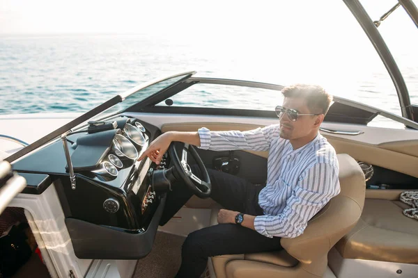 Aspirational uomo d'affari di successo in piedi da barche di lusso e yacht contro un cielo blu profondo, tenendo la giacca sopra le spalle. — Foto Stock