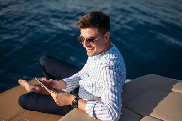 Empresário em viagem pelo mar lendo tablet computador no barco com tecnologia moderna, estilo de vida bem sucedido — Fotografia de Stock