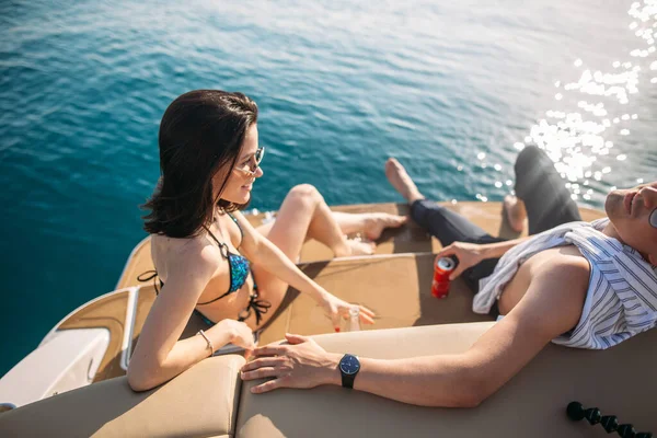 Casal feliz deitado num barco no mar. Férias de luxo em um iate nas ilhas. — Fotografia de Stock