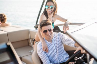 Genç evli çift motorlu teknede deniz gezintisi yapıyor.