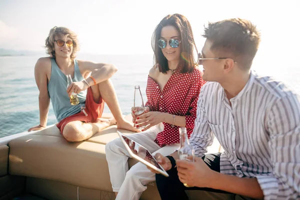 Iate bebendo cervejas enquanto conversa Grupo de amigos que fazem festa em barco à vela — Fotografia de Stock