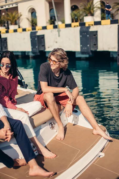 Amigos descansando no barco a motor no cais marinho, viajando em férias de verão. — Fotografia de Stock