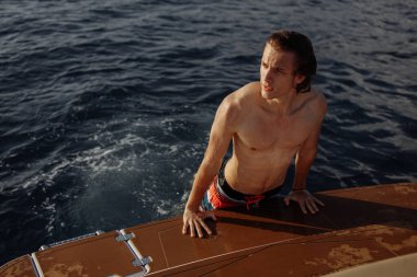 Kafkasyalı genç adam yat güvertesinde deniz yolculuğunun tadını çıkarıyor..