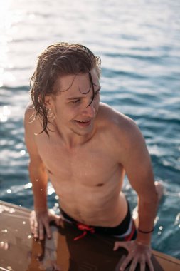 Kafkasyalı genç adam yat güvertesinde deniz yolculuğunun tadını çıkarıyor..