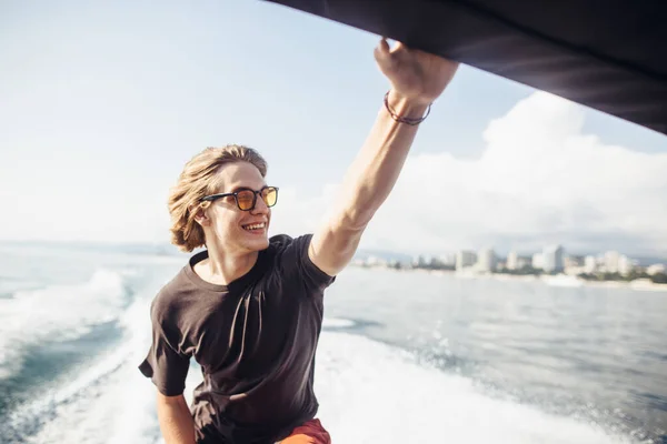 Young caucasian hipster guy enjoying journey on yacht deck sailing the sea. — Stock Photo, Image