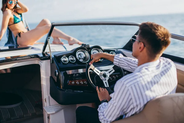 Young married couple having sea excursion on motor boat