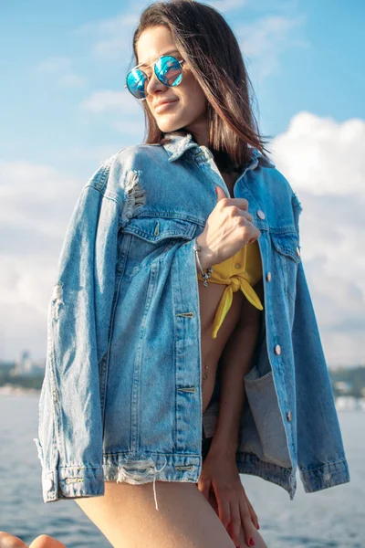 Chica joven en bikini y gafas de sol posando en un yate en un día soleado de verano —  Fotos de Stock