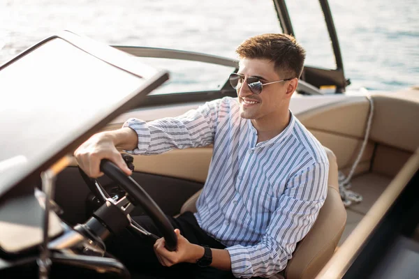 Empresário de sucesso inspirador em pé por barcos de luxo e iates contra um céu azul profundo, segurando sua jaqueta sobre o ombro. — Fotografia de Stock