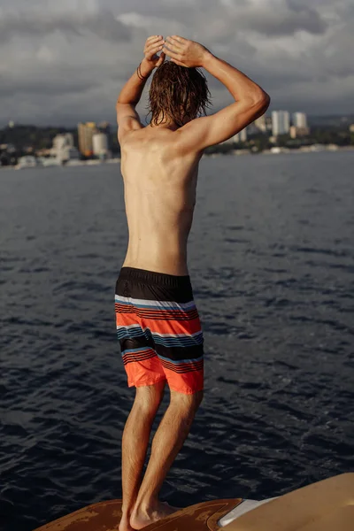 Jovem caucasiano hipster cara aproveitando viagem no iate deck vela o mar. — Fotografia de Stock