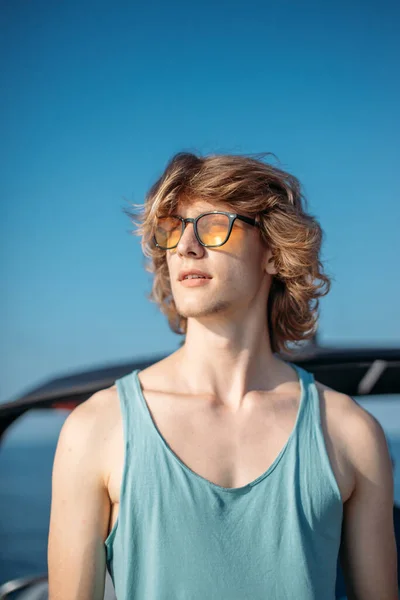 Pemuda hipster kaukasia menikmati perjalanan di geladak kapal pesiar berlayar laut. — Stok Foto