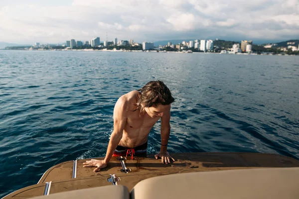 Freunde, die vom Boot ins Wasser springen. Freizeit und Spaß — Stockfoto