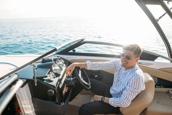 Aspirational uomo d'affari di successo in piedi da barche di lusso e yacht contro un cielo blu profondo, tenendo la giacca sopra le spalle. — Foto Stock