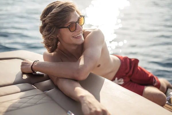 Jovem caucasiano hipster cara aproveitando viagem no iate deck vela o mar. — Fotografia de Stock