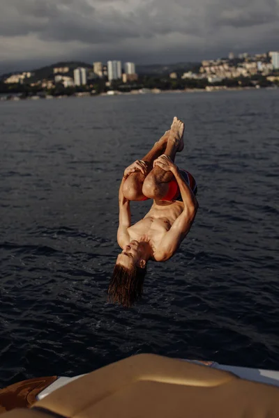 Ung kaukasisk hipster kille njuter resa på yacht däck seglar havet. — Stockfoto