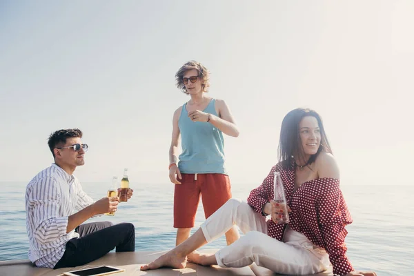 Iate bebendo cervejas enquanto conversa Grupo de amigos que fazem festa em barco à vela — Fotografia de Stock