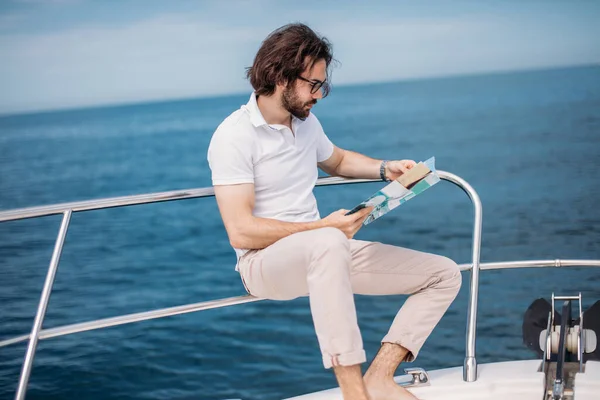 Młody brodaty mężczyzna na luksusowym jachcie ze wspaniałym widokiem na morze. — Zdjęcie stockowe