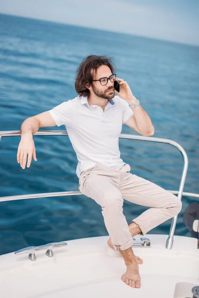 Молодой бородатый человек на роскошной яхте с великолепным видом на море. — стоковое фото