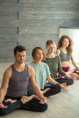 Sınıfta yoga poz veren bir grup genç..