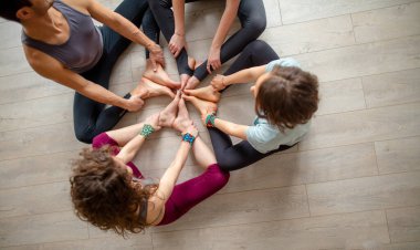 İnsanlar yoga dersinden sonra birlikte stüdyo zemininde oturup rahatlıyorlar..