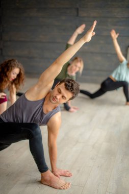 Yogaya başlayanlar gri duvara karşı egzersiz yapıyor, yoga yapıyor veya pilates yapıyor..