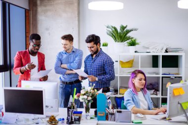 Modern ofisteki gençler yeni bir proje üzerinde tartışıyorlar.