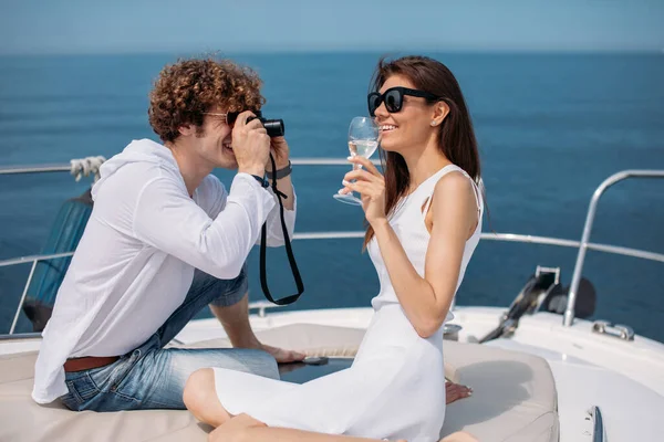 Attractive couple on the yacht. Young man is taking photo of his girlfriend — Stock Photo, Image