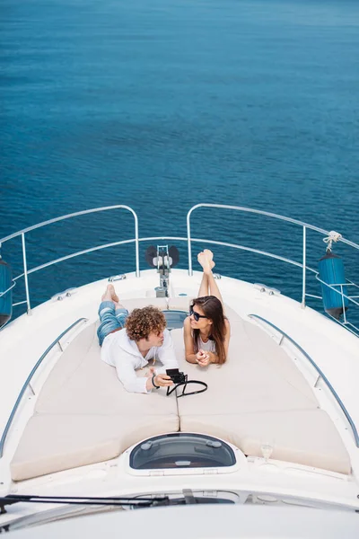 Attractive couple on the yacht. Young man is taking photo of his girlfriend — Stock Photo, Image