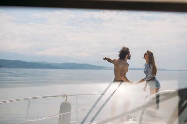 Leidenschaftliche Liebhaber tanzen auf dem Bug von Deck, während sie auf einer Jacht segeln. — Stockfoto