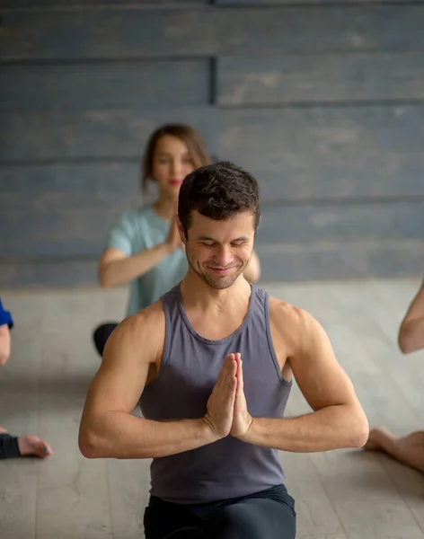 Yakışıklı genç kaslı adam, yoga hocası beyaz kadınlara yoga yapıyor.. — Stok fotoğraf