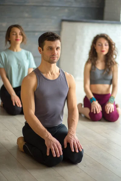 Spor erkek eğitmeni. Stüdyoda bir grup genç kadınla yoga yapıyor.. — Stok fotoğraf