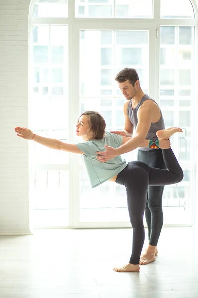 Istruttore di Yoga professionale aiuta principiante femminile a fare asana in studio. — Foto Stock