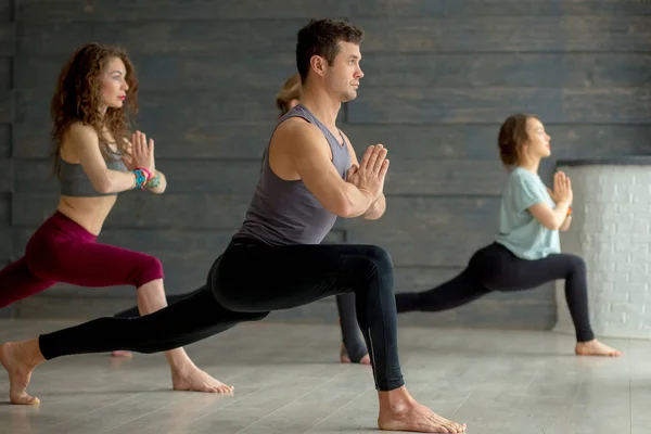 Yoga αρχάριοι γυμνάζονται σε γκρι τοίχο, κάνουν γιόγκα ή πιλάτες στάση. — Φωτογραφία Αρχείου