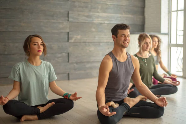 Groep jonge mensen die yoga lotus poseren in de klas. — Stockfoto