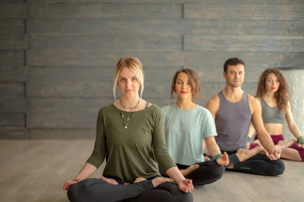 Yoga eğitimi. Bacak bacak üstüne atmış, yerde oturmuş meditasyon yapan insanlar.. — Stok fotoğraf