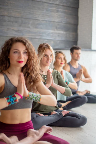 Mooie jonge vrouw in sportkleding beoefenen van yoga, zitten in lotus positie — Stockfoto