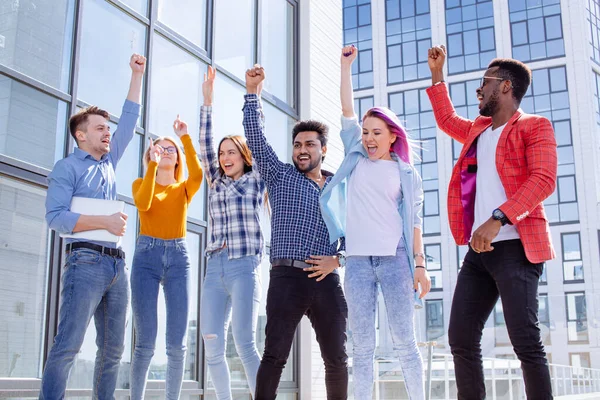 Group of multi ethnic youngsters chilling in urban outdoor background