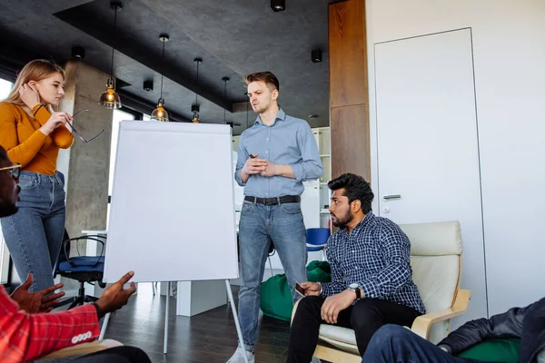 Giovane imprenditrice prepara una presentazione in piedi di fronte a un flip chart — Foto Stock