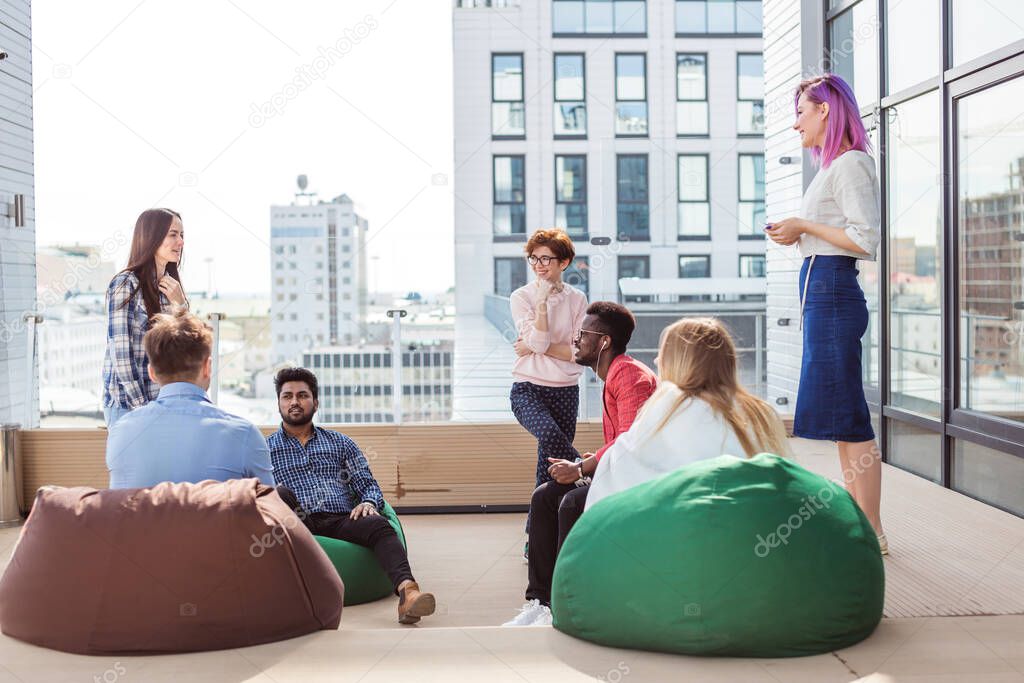 People discussing working process while sitting at the office lounge outdoor