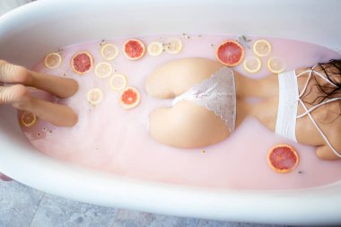 Mükemmel kadın kalçaları, dantelli küloduna sarılıp portakallı süt banyosuna tıkıştırılır.