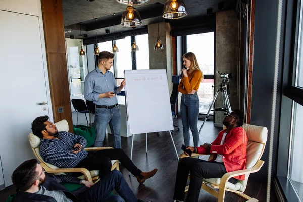 Personnes multi-ethniques planifiant une stratégie d'entreprise avec un schéma sur tableau à feuilles mobiles — Photo