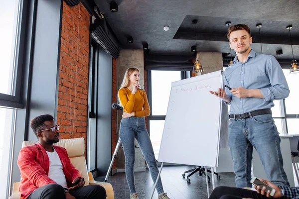 Gente multiétnica que planea estrategia de negocio con esquema en el rotafolio — Foto de Stock