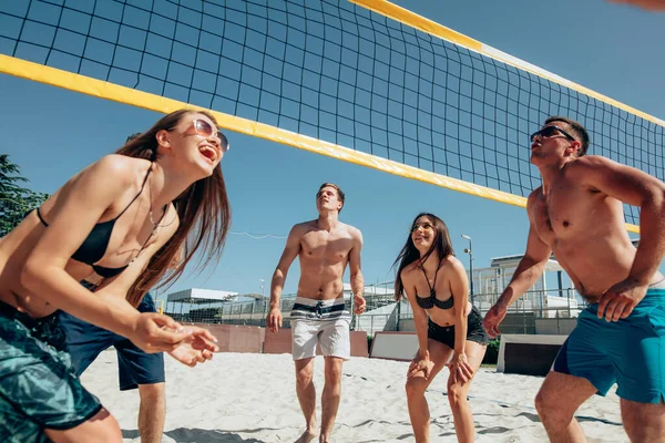 Grupo de jovens jogando vôlei de praia na areia — Fotografia de Stock
