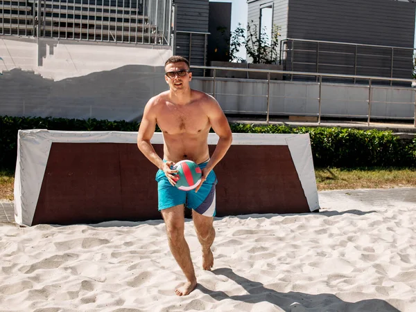 Voleibol praia jogador masculino se preparando para servir a bola na quadra de praia. — Fotografia de Stock