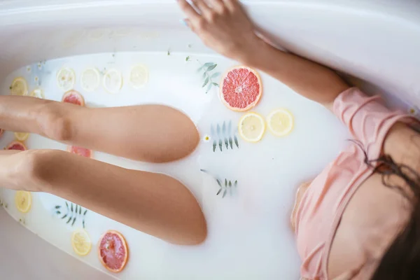 Hermosa mujer sexy en el baño de leche con flores — Foto de Stock