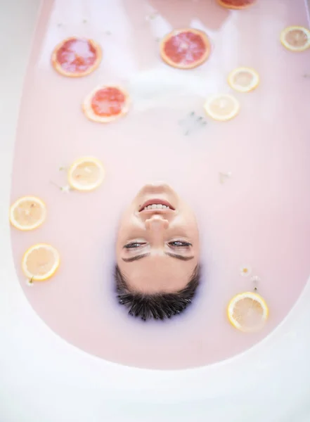 Cara de mujer en baño de leche. Spa concepto de cuidado de la piel. Rostro sano y rejuvenecimiento. — Foto de Stock