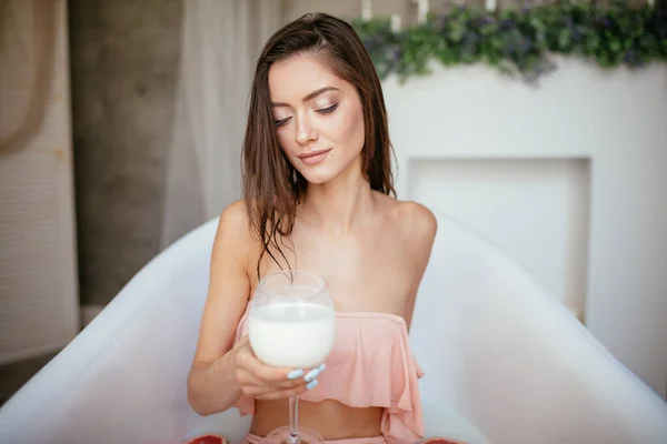 Şehvetli çekici kadın bir bardak sütle banyo yapıyor.. — Stok fotoğraf
